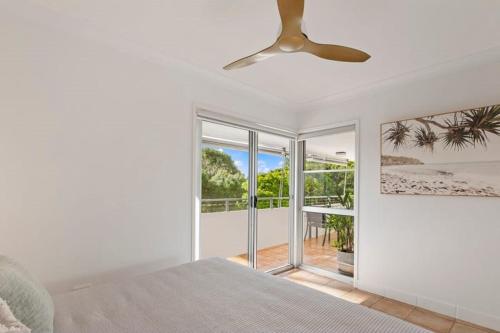 a bedroom with a bed and a ceiling fan at Yaringa Noosa Heads - Ocean View, Walk to Beach in Noosa Heads