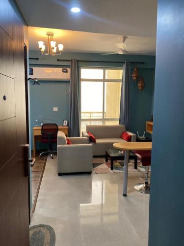 sala de estar con sofá y mesa en Aqua Inn - Studio Apartment, en Greater Noida