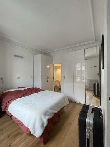- une chambre avec un grand lit et une valise dans l'établissement Batignolles-Montmartre / Mathieu, à Paris