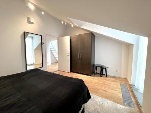 a bedroom with a black bed and a wooden floor at Elegant Apartment In The Heart Of The City in Gothenburg