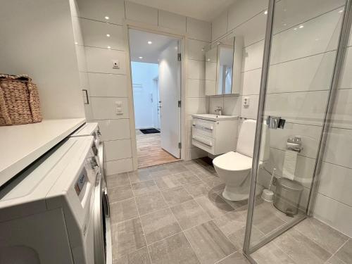 y baño blanco con aseo y ducha. en Elegant Apartment In The Heart Of The City en Gotemburgo