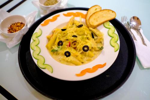a plate of food with pasta and crackers on a table at Finn's Weaver Resort, Kaziranga in Kāziranga