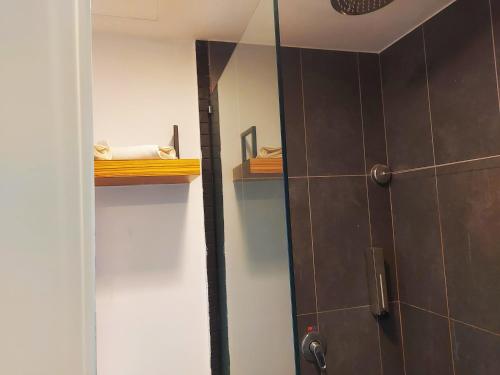a bathroom with a shower stall and a mirror at The Leverage Lite Hotel - Kuala Kedah in Alor Setar