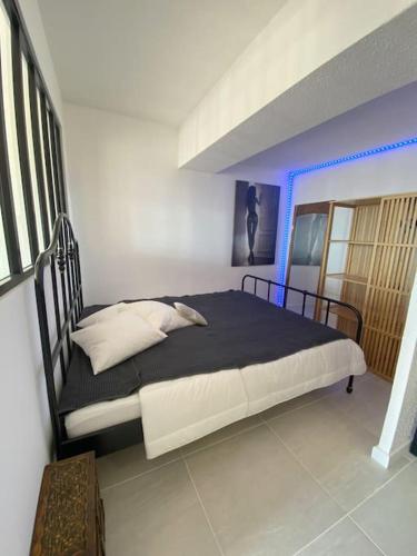 une chambre avec un lit avec un cadre de lit noir dans l'établissement Studio 535, Port Nature 5 au village naturiste, au Cap d'Agde