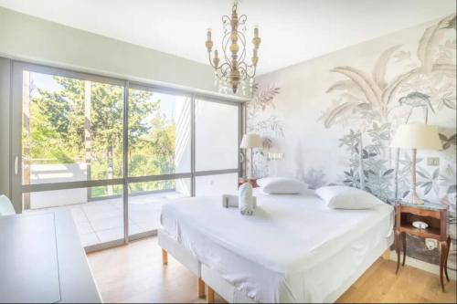 - une chambre avec un grand lit blanc et une grande fenêtre dans l'établissement 3RAM - Magnifique aptt situé en face des plages du Prado, à Marseille