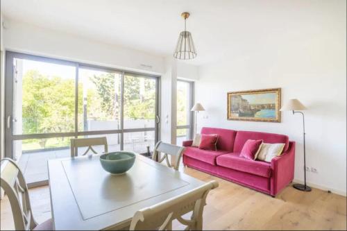 un salon avec un canapé rose et une table dans l'établissement 3RAM - Magnifique aptt situé en face des plages du Prado, à Marseille