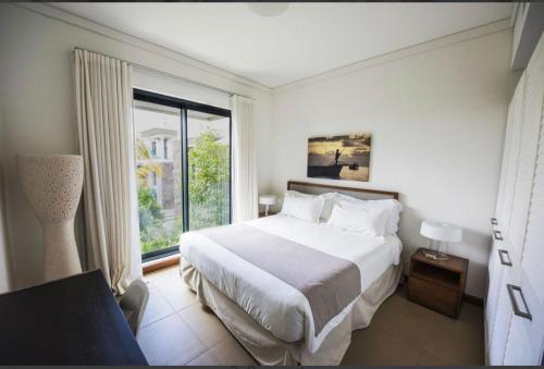 una camera con un grande letto e una grande finestra di Luxury room by Grand Vacations a Roches Noires