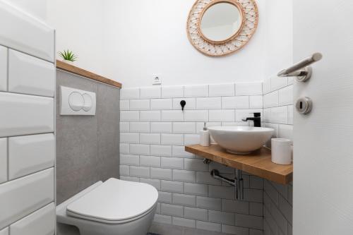 a bathroom with a white toilet and a sink at Apartman 114 in Baška