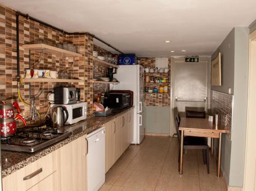 a kitchen with a counter with a stove and a refrigerator at Yeşim Suit Otel in Istanbul