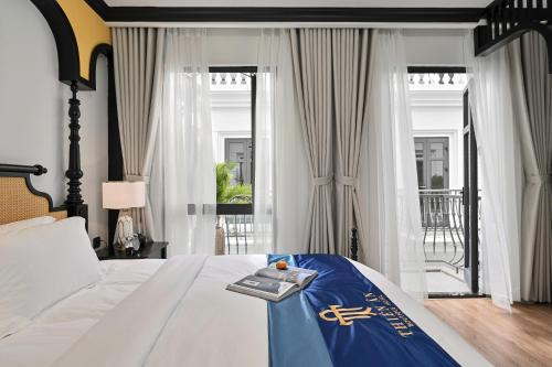 una habitación de hotel con una cama con un libro encima en Thiên Ân Boutique Hotel, en Bạc Liêu