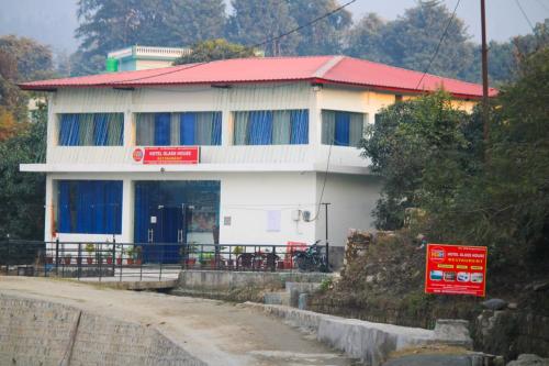 un edificio bianco con tetto rosso su una strada di Hotel Glass House a Kāta Patthar