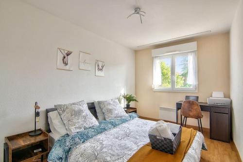 une chambre avec un lit, un bureau et une fenêtre dans l'établissement T2 Calme et Lumineux à Colomiers proche Airbus, à Colomiers