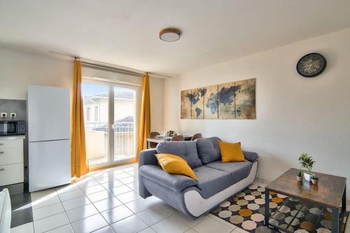 un salon avec un canapé bleu et une cuisine dans l'établissement T2 Calme et Lumineux à Colomiers proche Airbus, à Colomiers