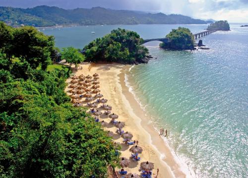 a beach with umbrellas and people on the beach at Eurostars Grand Cayacoa in Santa Bárbara de Samaná