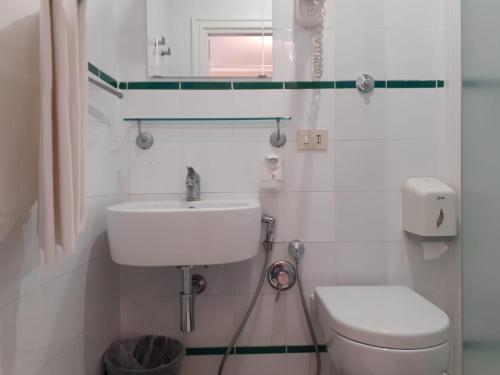 ローマにあるホテル インディペンデンツァの白いバスルーム(洗面台、トイレ付)