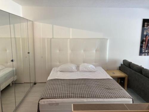 une petite chambre avec un lit et un canapé dans l'établissement Villa 181, Port Nature, au village naturiste, au Cap d'Agde