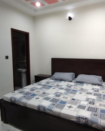 1 dormitorio con 1 cama con edredón azul y blanco en Comfy room, en Rawalpindi