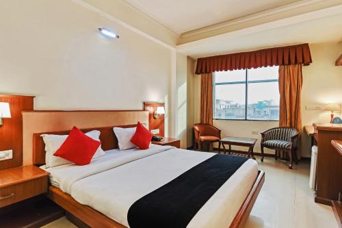 una habitación de hotel con una cama grande con almohadas rojas en Hotel Royal Empire en Jaipur