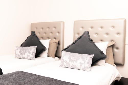 two beds with black and white pillows in a bedroom at Mandela Rhodes Place in Cape Town