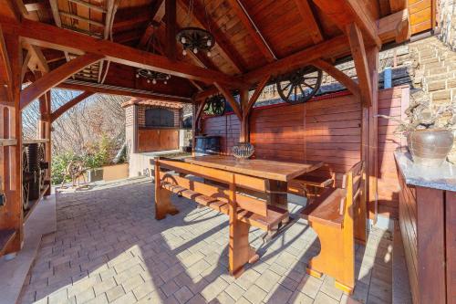 eine Außenküche mit einem Holztisch auf einer Terrasse in der Unterkunft Zidanica med Trtami in Dvor