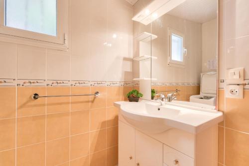 une salle de bain avec un lavabo, des toilettes et un miroir dans l'établissement 700m plage d'Arès- Jardin et pins, maison pour 4, à Arès
