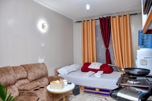 a small living room with a couch and a bed at JoJo Jovial Homes in Kiambu
