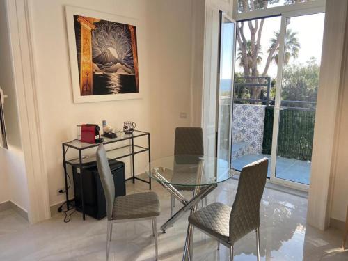 une salle à manger avec une table et des chaises en verre dans l'établissement Megaride Domus, à Ercolano