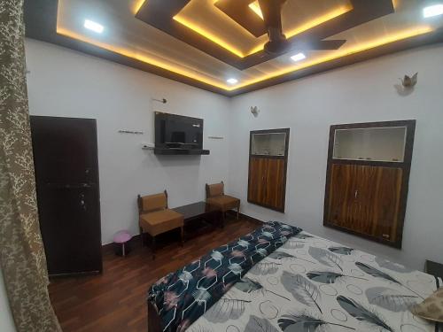 um quarto com uma cama e uma televisão de ecrã plano em The blessings home stay em Agra