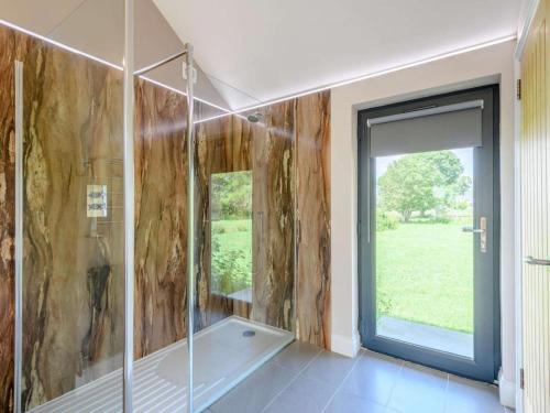 baño con ducha y puerta de cristal en Romantic cottage for 2 with hot tub en Wimborne Minster