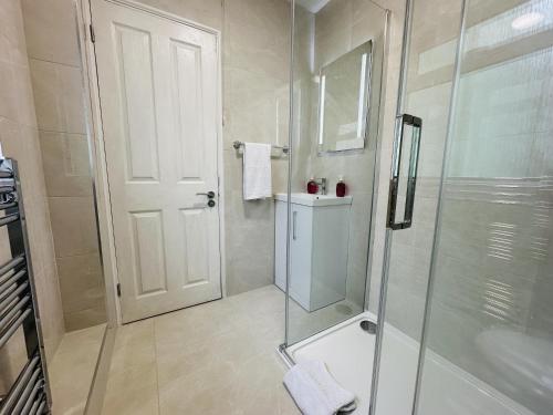 a bathroom with a shower and a glass door at City central location, 2 min to the sea, 4-bedroom St Margarers townhouse, car-park & conference centre nearby, shops, coffee shops & restaurants - walking distance in Brighton & Hove