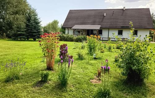 a garden in front of a house with flowers at Siedlisko Czarny Kot in Lądek-Zdrój