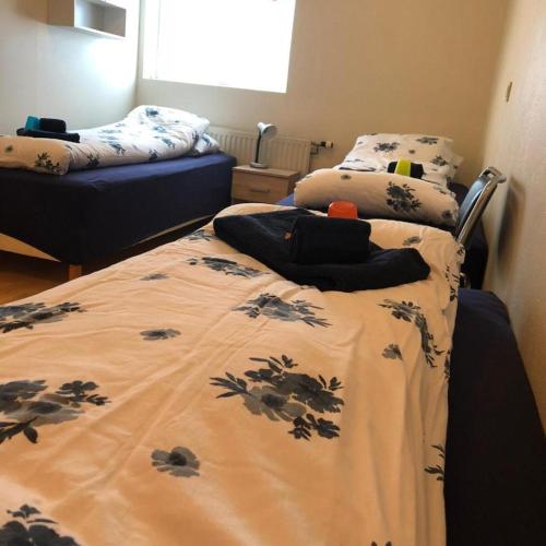 a bedroom with two beds and a bed with a blanket at Vestmannsvatn Guesthouse in Aðaldalur