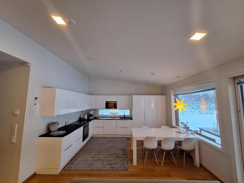 a kitchen with a white table and a dining room at Villa Arctic Light in Rovaniemi