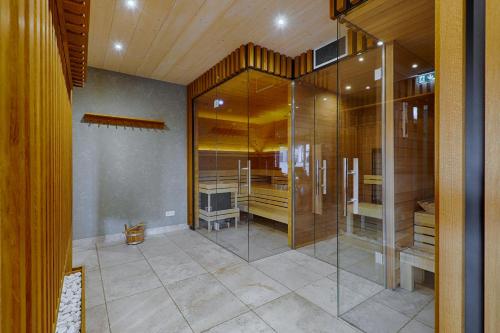 a bathroom with a glass shower and a television at Strandhäuser Blankenfohrt in Ueckeritz