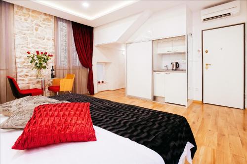 a bedroom with a bed and a table and a kitchen at Get Split Luxury Apartment in Split
