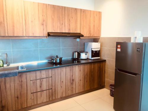 a kitchen with wooden cabinets and a stainless steel refrigerator at Kulai d'putra suites beside ioiMall near Airport and JPO in Kulai