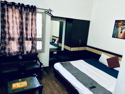a small bedroom with a bed and a window at HOTEL SUNSHINE in Nagpur