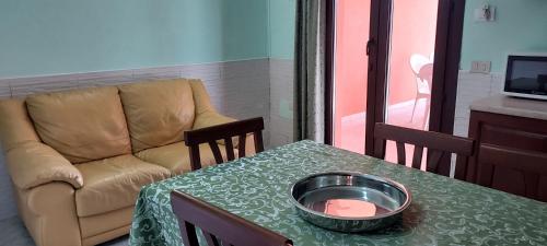 a living room with a couch and a table with a bowl on it at LA ROSA DEI VENTI ACCOMADACION in Chia