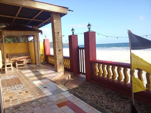 uma vista para a praia a partir do alpendre de uma casa de praia em Koa's Beach House em Tangalan