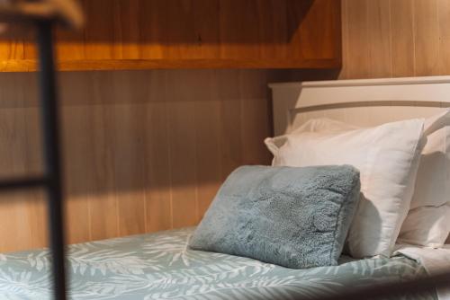 a bed with a pillow and some white pillows at Ora Retreat in Queenstown