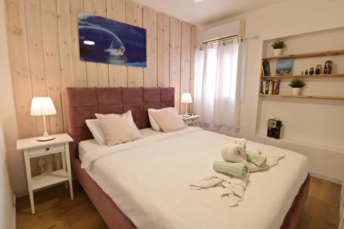 Un dormitorio con una cama con un osito de peluche. en יחידת בוטיק מעוצבת עם נוף למפרץ במיקום מצויין, en Eilat