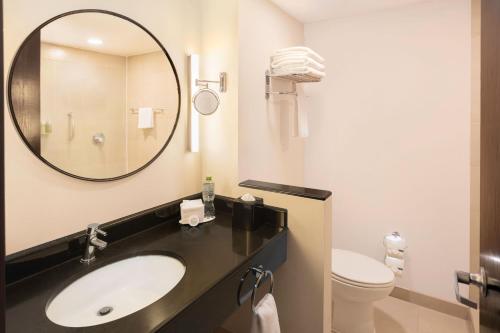 a bathroom with a sink and a mirror and a toilet at Fairfield by Marriott Los Cabos in Cabo San Lucas