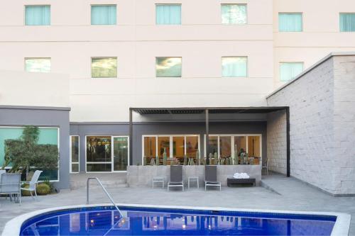 a building with a swimming pool in front of a building at Fairfield by Marriott Los Cabos in Cabo San Lucas