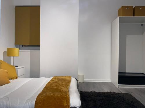 a bedroom with a white bed with a brown blanket at MODERN APARTMENT-GREENWICH/WOOLWICH in Woolwich