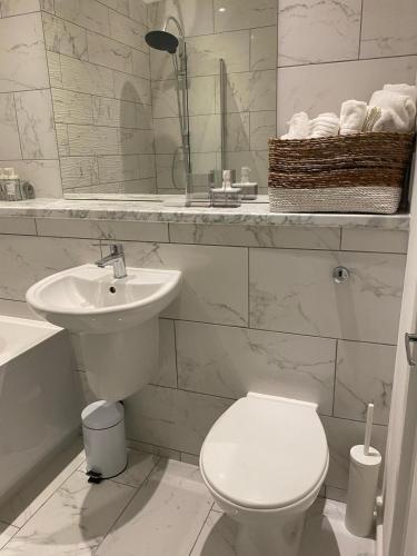 bagno bianco con servizi igienici e lavandino di MODERN APARTMENT-GREENWICH/WOOLWICH a Woolwich