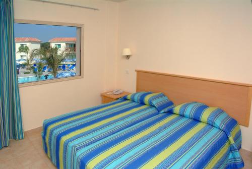 a bedroom with a bed with a view of a resort at Tsokkos Paradise Holiday Village in Ayia Napa