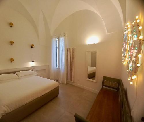 um quarto com uma cama, uma janela e um lustre em Li Frati Suite em Lecce