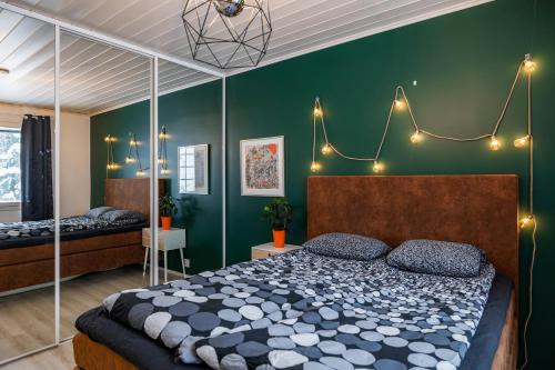 a bedroom with a bed and a green wall at Cozy & luxurious relaxation - Suopursu Lux in Rovaniemi