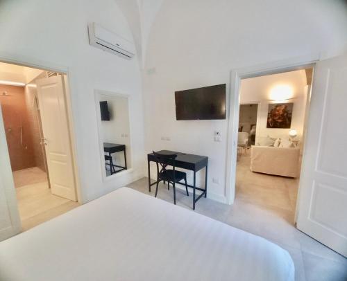 a white bedroom with a bed and a living room at Li Frati Suite in Lecce