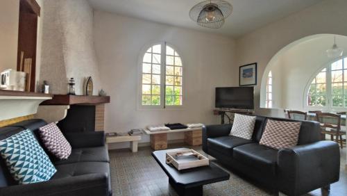 un salon avec un canapé et une cheminée dans l'établissement Maison Sarah Bernhardt tout confort, à Andernos-les-Bains